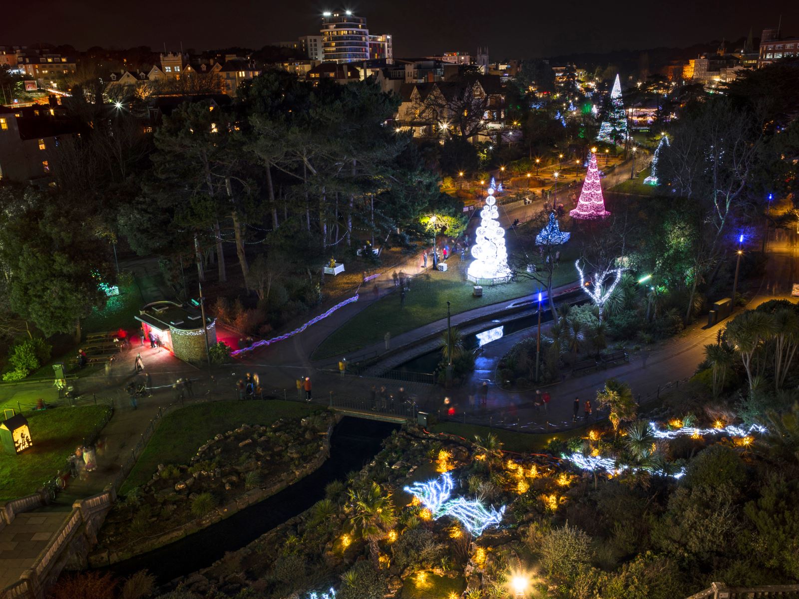 An aerial shot taken of Bournemouth's Christmas Tree Wonderland, with a pink and a white tree illuminating the night sky